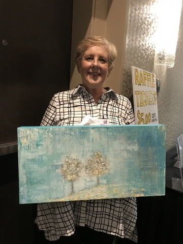 Winner MaryLynn Posner Rhodes with painting donated to raffle by Terry Fontaine